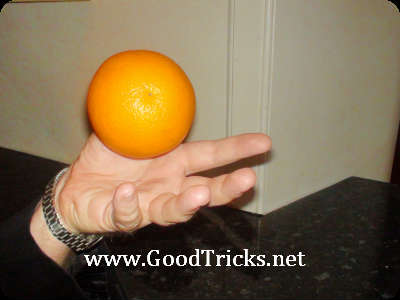 An orange appears to float above your hand.