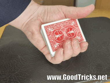 Playing cards being held in the mechanics grip in preparation to do a card sleight.